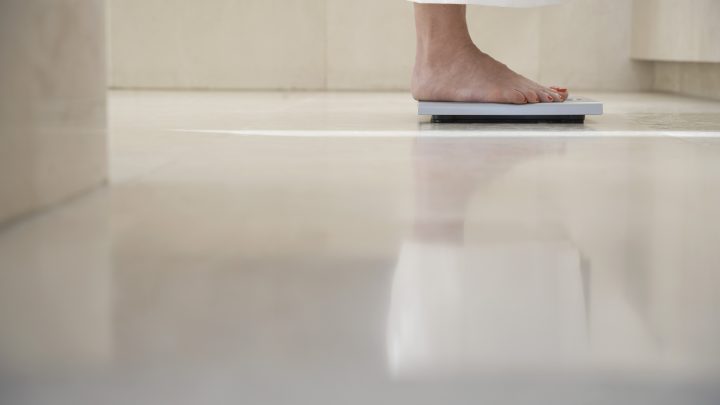 Woman on a bathroom scale. Only her feet are visible.